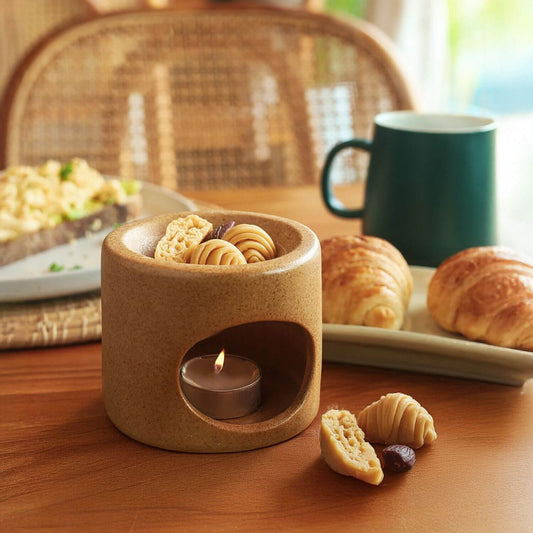 แว็กซ์หอมกลิ่นขนมปังอบใหม่ กลิ่น Croissant & Toast วางบนเตาอโรมาเซรามิก สร้างบรรยากาศมื้อเช้าที่อบอุ่นด้วยกลิ่นเนยสด