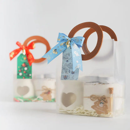 ถุงของขวัญใส Christmas Gift Set สองแบบ โบว์ฟ้าและโบว์แดง ด้านในมีเตาอโรมามินิ กระปุกแว็กซ์หอม และขวดไม้ขีดไฟ