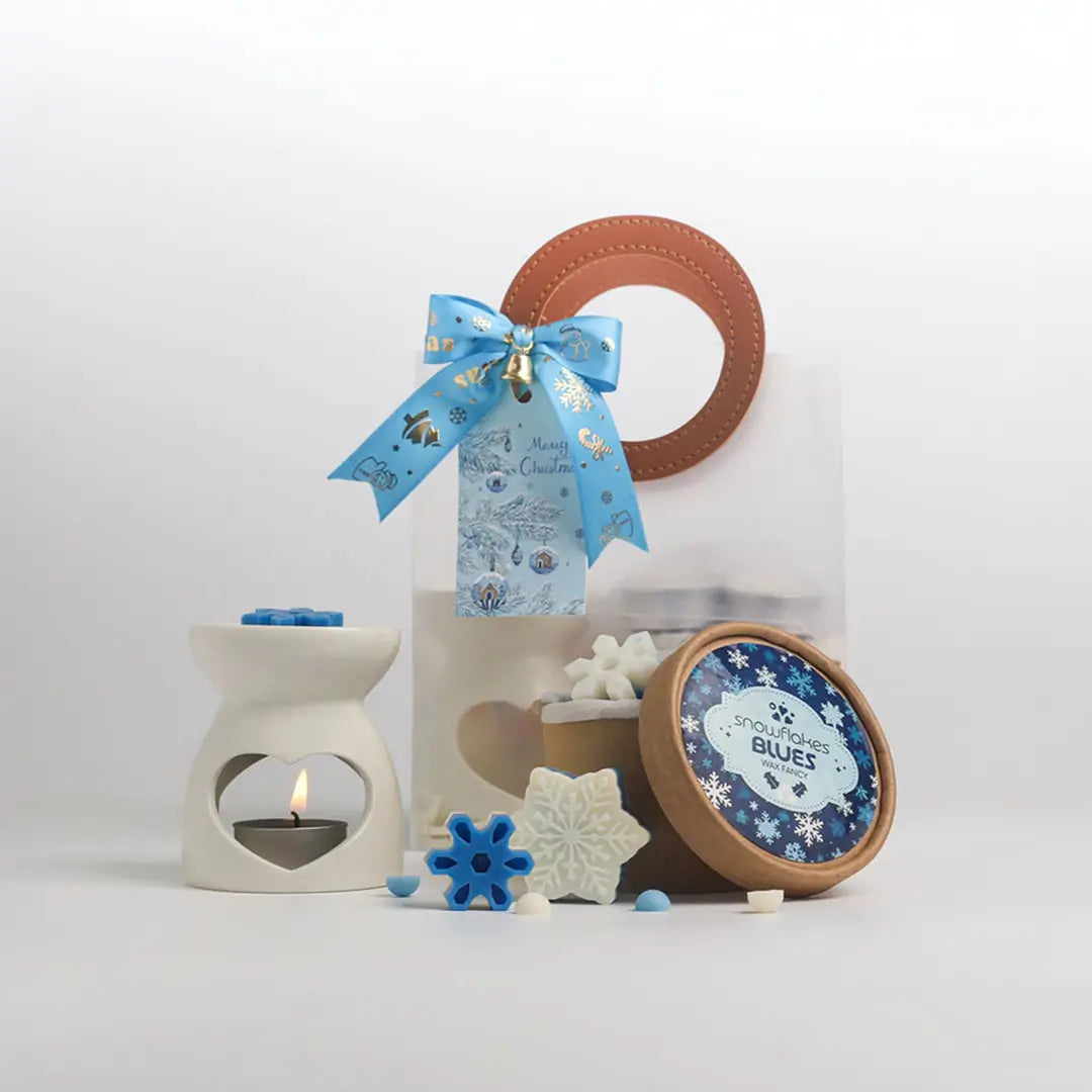 Christmas Gift Set กลิ่น Snowflakes Blues: เตาอโรมาเซรามิกมินิ กระปุกแว็กซ์หอม และถุงของขวัญใสผูกโบว์ฟ้าพร้อมการ์ด บนพื้นหลังสีขาว