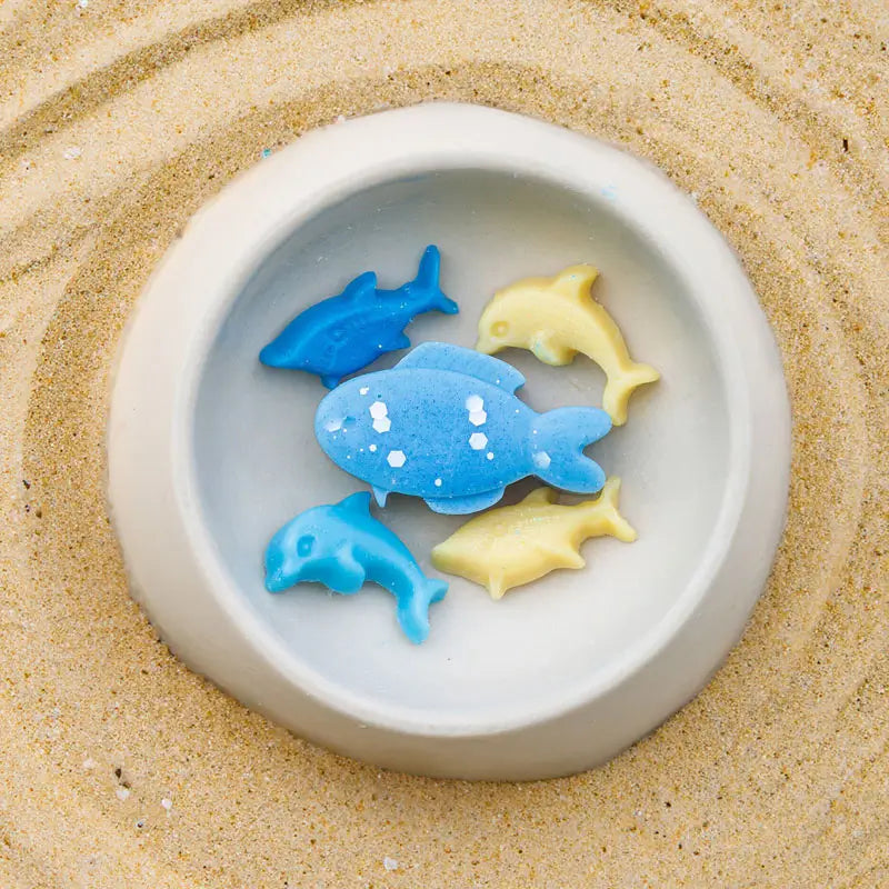 แว็กซ์หอมรูปปลา Ocean Breeze Premium Wax Fancy ในเตาอุ่นเซรามิก มุมสูงระยะใกล้ พื้นหลังทราย