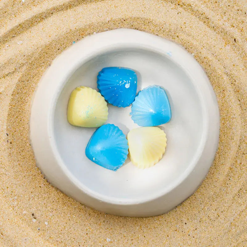 แว็กซ์หอมรูปเปลือกหอย Ocean Breeze Premium Wax Fancy ในเตาอุ่นเซรามิก มุมสูงระยะใกล้ พื้นหลังทราย